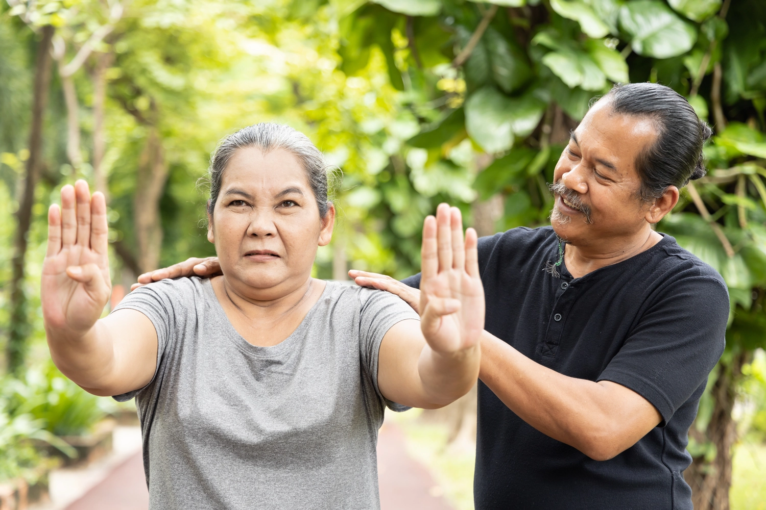 Chan tao - Institut für Gesundheit - Gestresste alte Frau praktiziert chinesisches Gongfu Qigong, trainiert von ihrem leitenden Personal Trainer